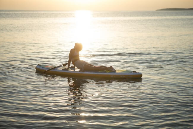 Woman doing yoga on a Red Paddle Co SUP board